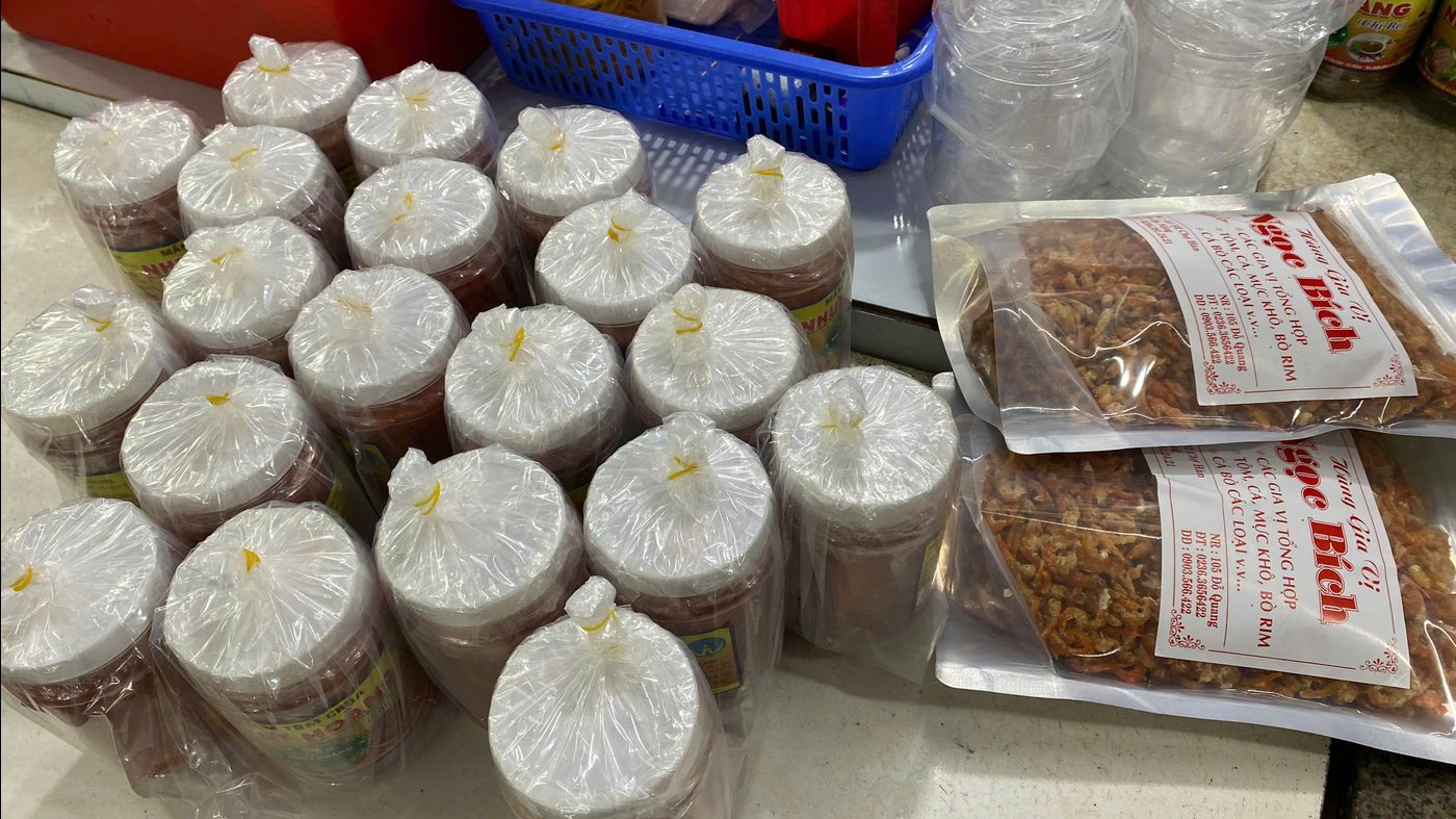 Tarros de salsa fermentada envueltos en plástico sobre un mostrador del mercado