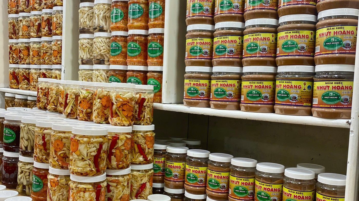 Puesto de salsas fermentadas en el mercado Han con tarros apilados en estanterías