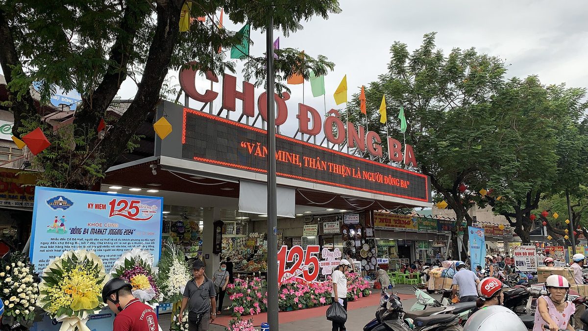 Lối bên hông chợ Đông Ba, hàng hoa và xe máy