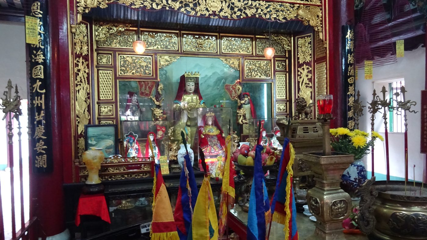 Bên trong một hội quán người Hoa ở Hội An với ban thờ và cờ nhiều màu