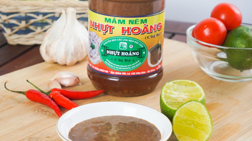 Chén mắm nêm đã pha với thơm băm, tỏi ớt, bên cạnh là chanh cắt đôi