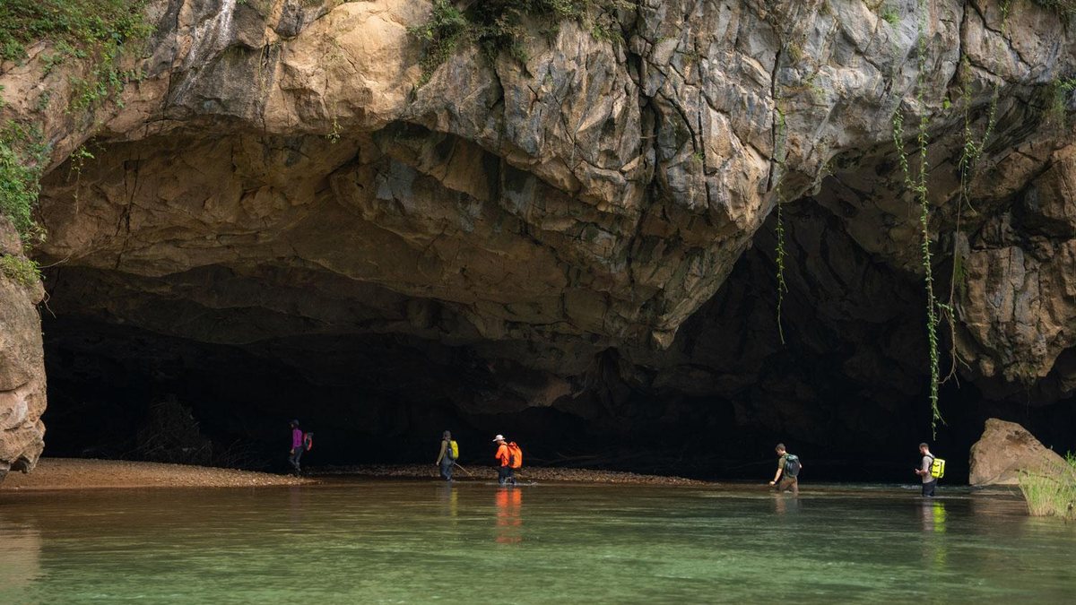 Đoàn khách lội qua dòng nước ở cửa Hang Én